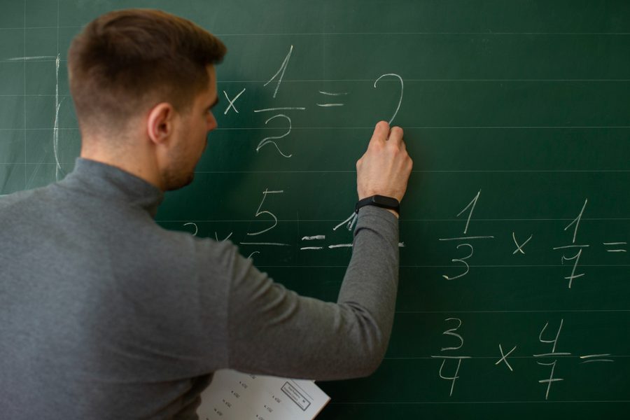 Algebra tutoring — teacher writing equations on a chalkboard